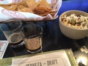 From the top, clockwise:  Housemade tortilla chips, 7 Layer Dip, New Belgium Salted Chocolate Stout, Stone  Coffee Milk Stout
