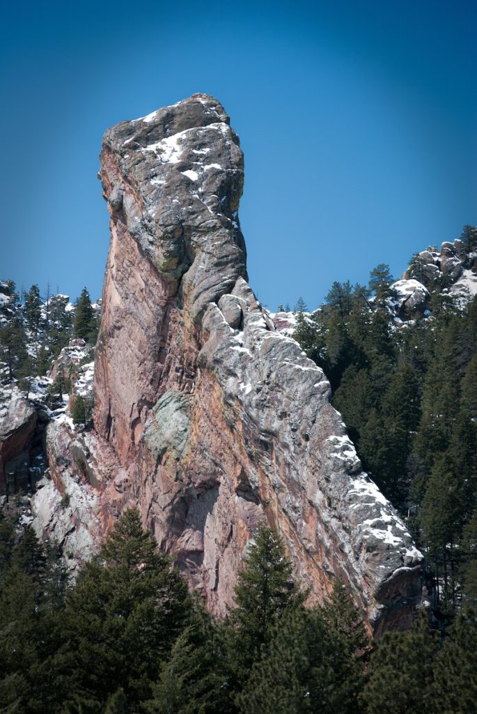 green pine trees on brown rocky mountain under blue sky during daytime