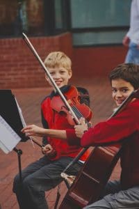 boy in red long sleeve shirt playing violin