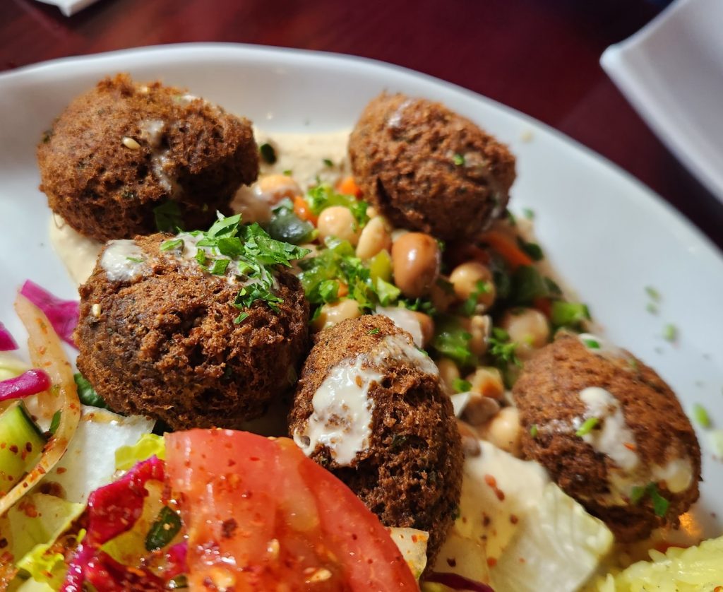 a white plate topped with meatballs and a salad