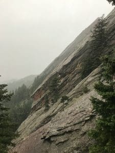 a view of a rocky mountain with trees on the side