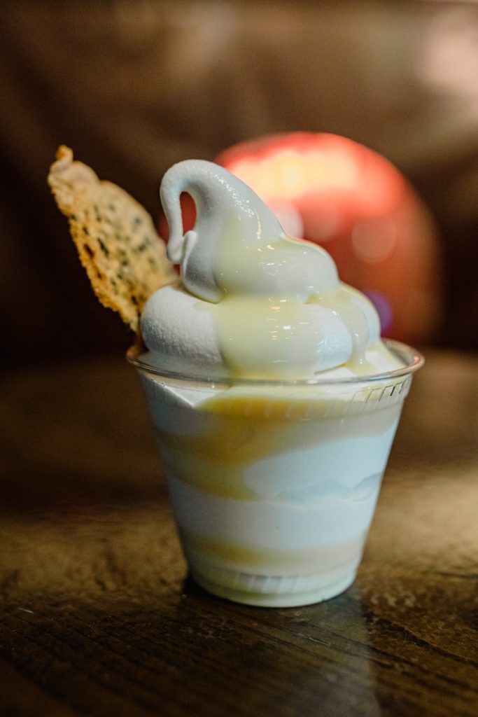 a cup of ice cream with a cracker in it