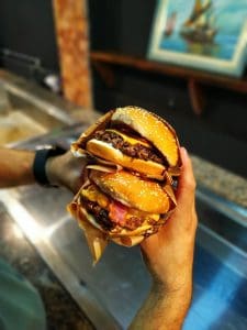 Person Holding Two Burgers