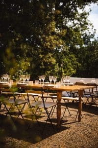 a wooden table topped with lots of empty wine glasses