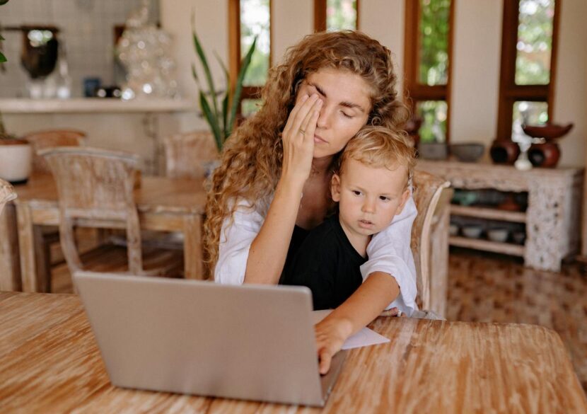 Woman multitasking while working from home with child. Relaxed ambiance.