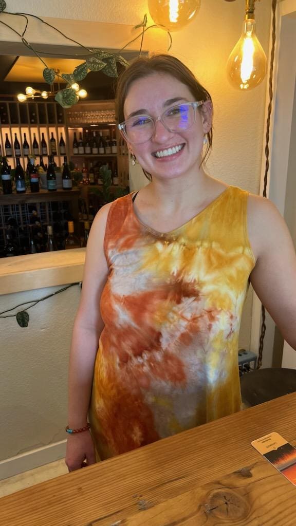 Alexandrea smiling behind the counter at Public Wine