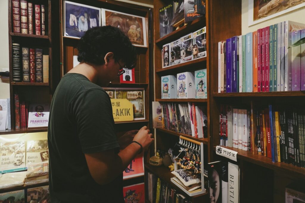 A person browses bookshelves in a cozy bookstore - AboutBoulder.com