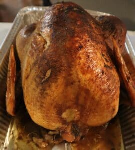 A roasted turkey sitting on top of a pan