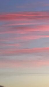 light red bands of clouds over a blue sky