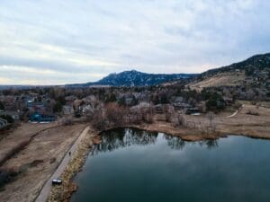 A calm lake and town scenery under a cloudy sky.