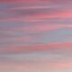 light red bands of clouds over a blue sky