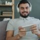 Man wearing headphones plays game on smartphone