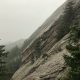 a view of a rocky mountain with trees on the side