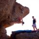 a man standing on top of a rock next to another man