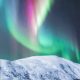 Colorful polar lights over snowy mountain